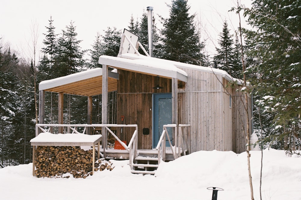 a small wooden cabin in the middle of a snowy forest