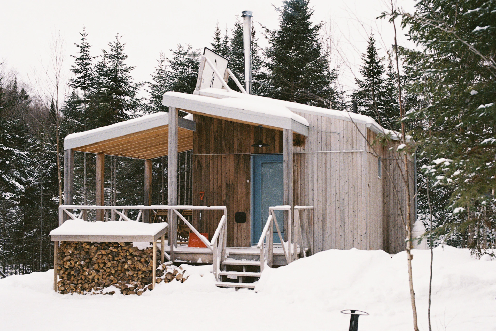 a small wooden cabin in the middle of a snowy forest