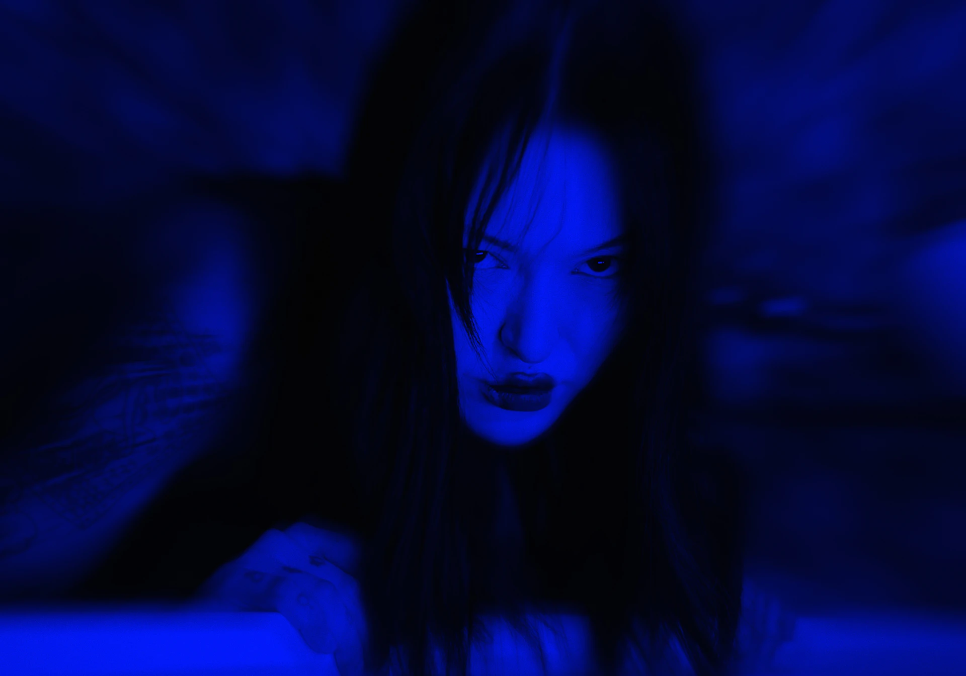 a woman in a dark room with a blue light