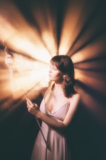 a woman in a white dress holding a wand