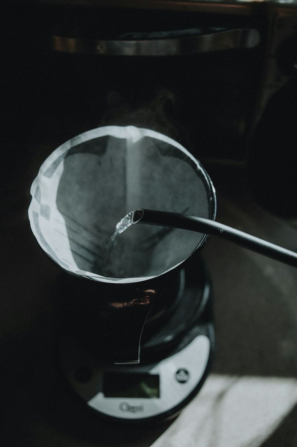 a black coffee pot sitting on top of a scale