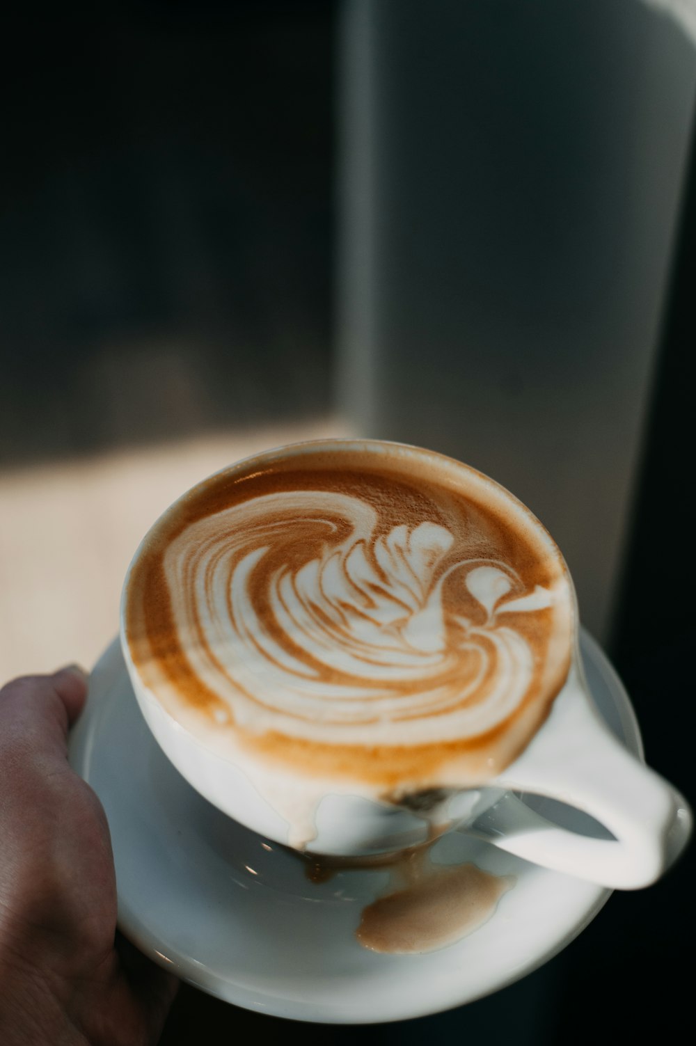 a person holding a cup of coffee in their hand