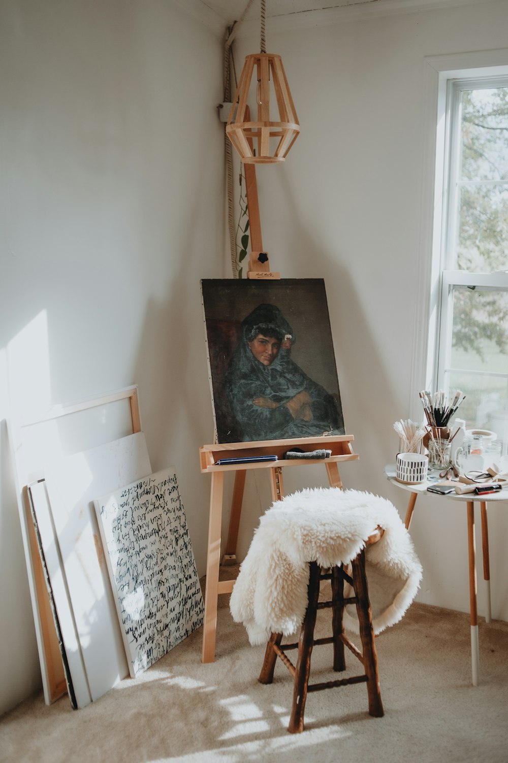 una stanza con una sedia e un dipinto su un cavalletto