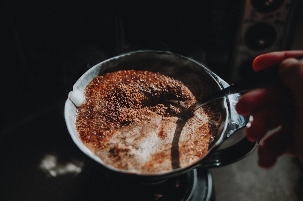 a person is stirring a cup of hot chocolate