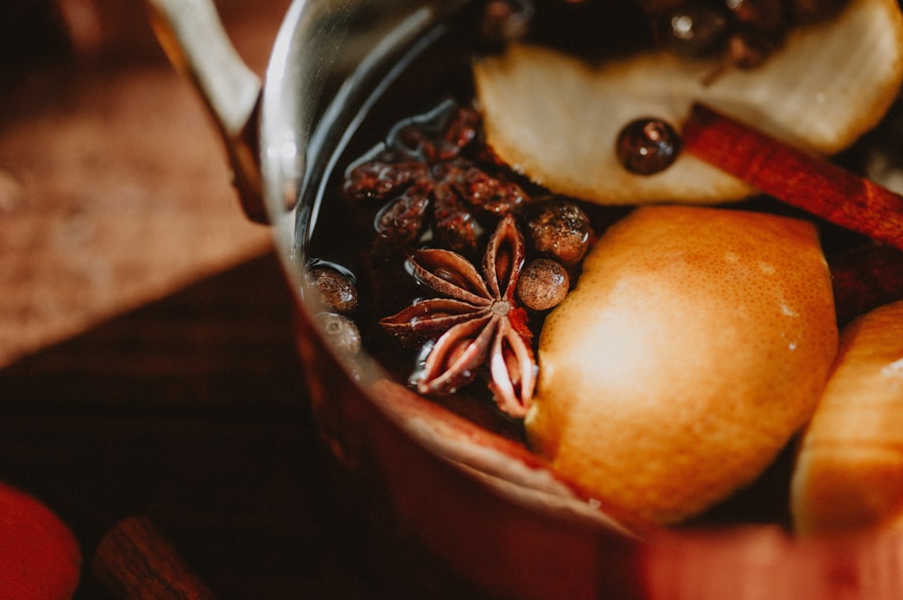 a pot filled with fruit and nuts on top of a table