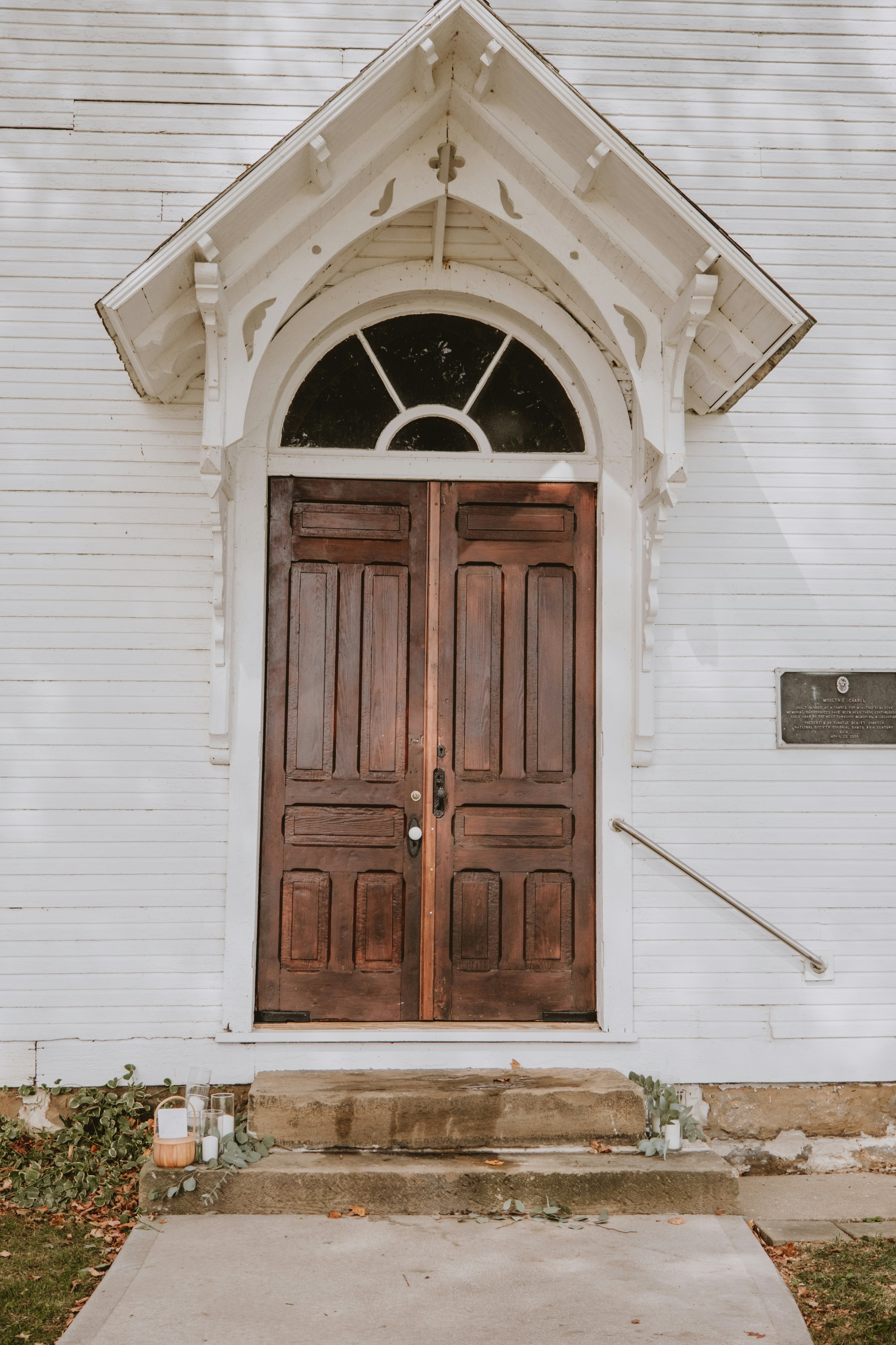 une église blanche avec deux portes brunes et un clocher