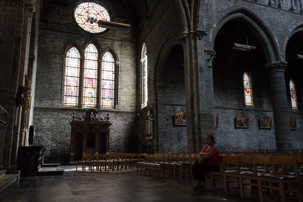 a woman sitting on a bench in a church