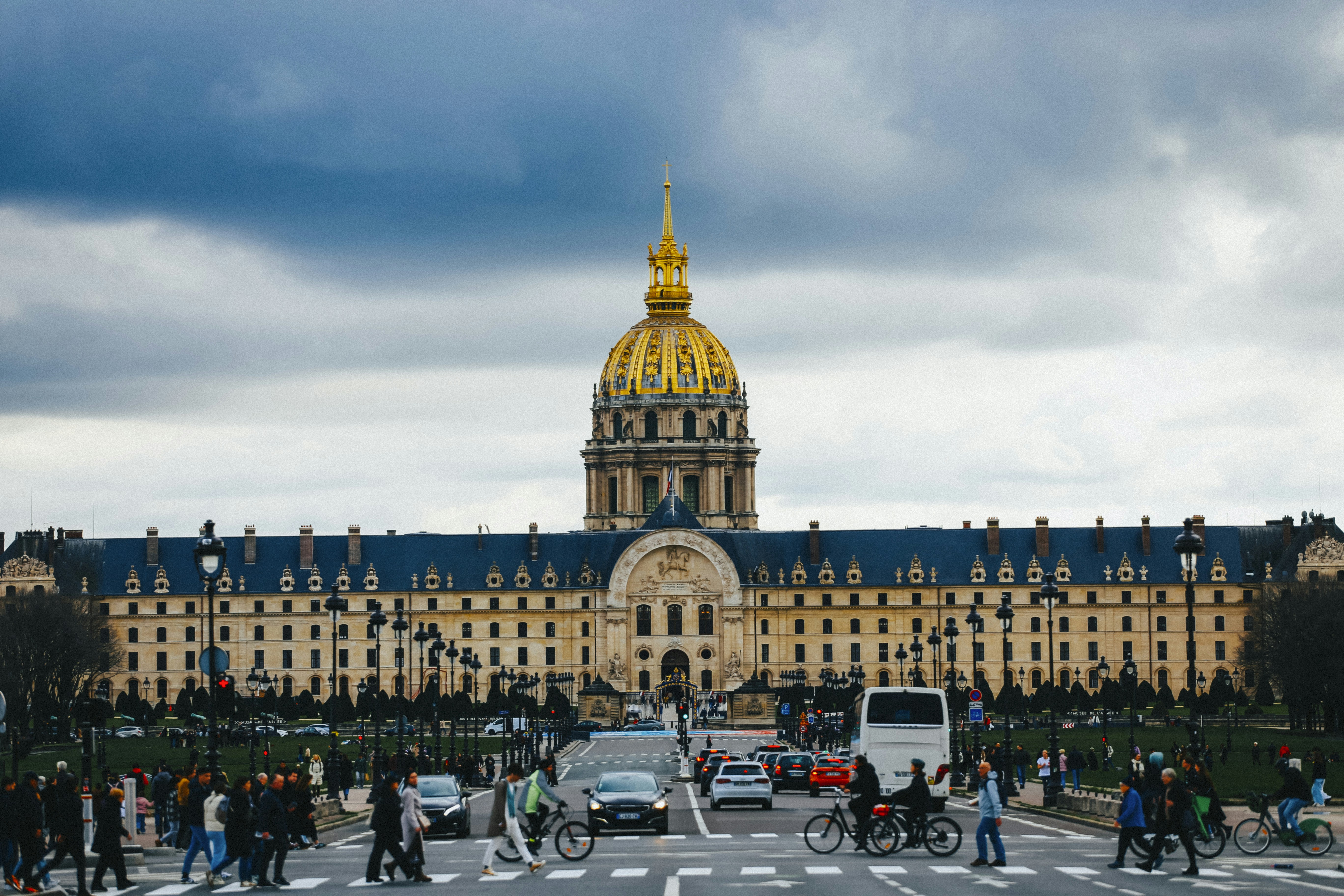 um grupo de pessoas atravessando uma rua em frente a um grande prédio