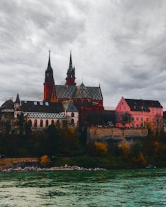 a large building with two towers next to a body of water