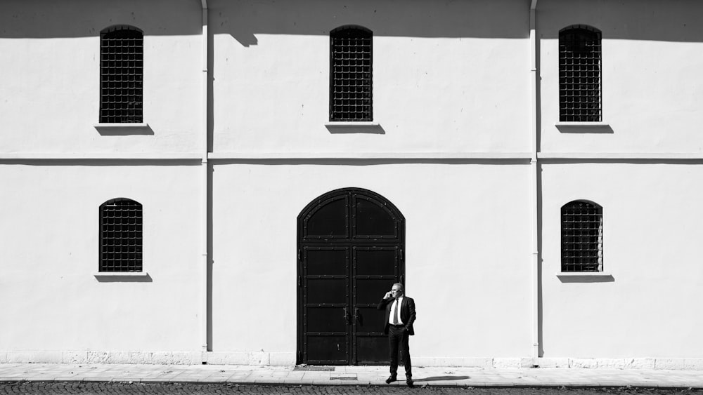 a man standing in front of a white building