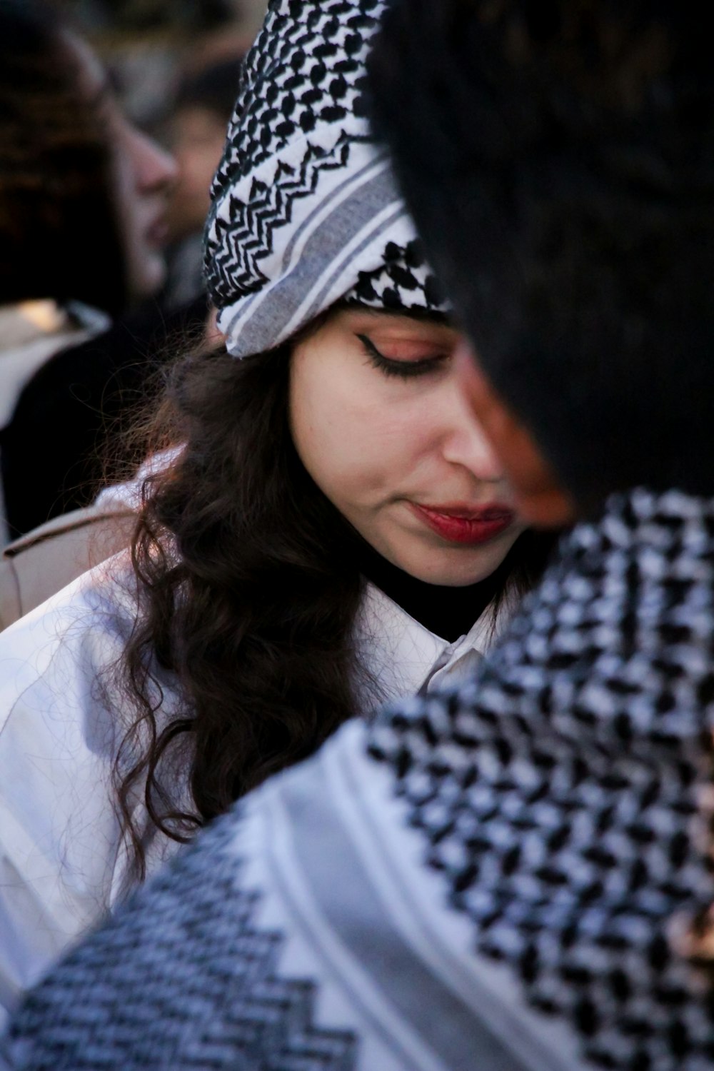 a woman wearing a hat looking down at her cell phone