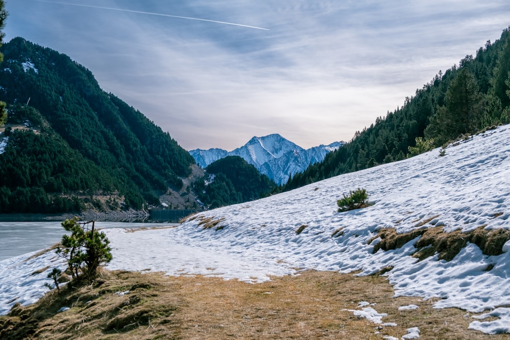 a view of a snow covered mountain with a lake in the foreground