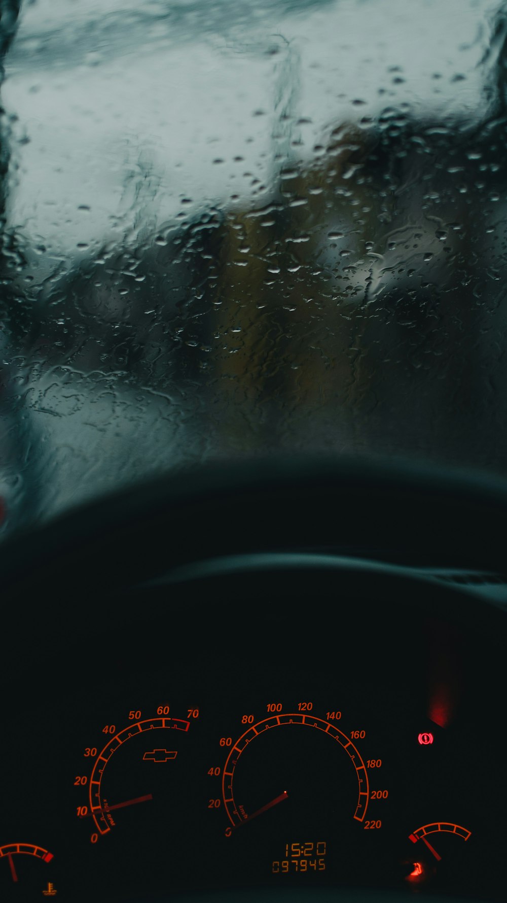 the dashboard of a car with rain on it