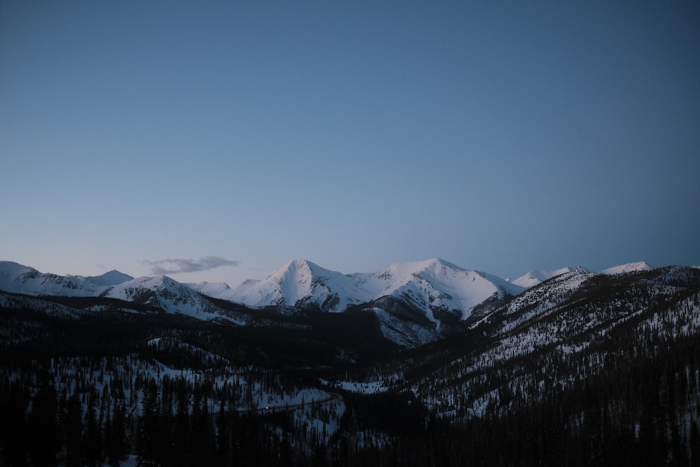 a mountain range with snow covered mountains in the distance