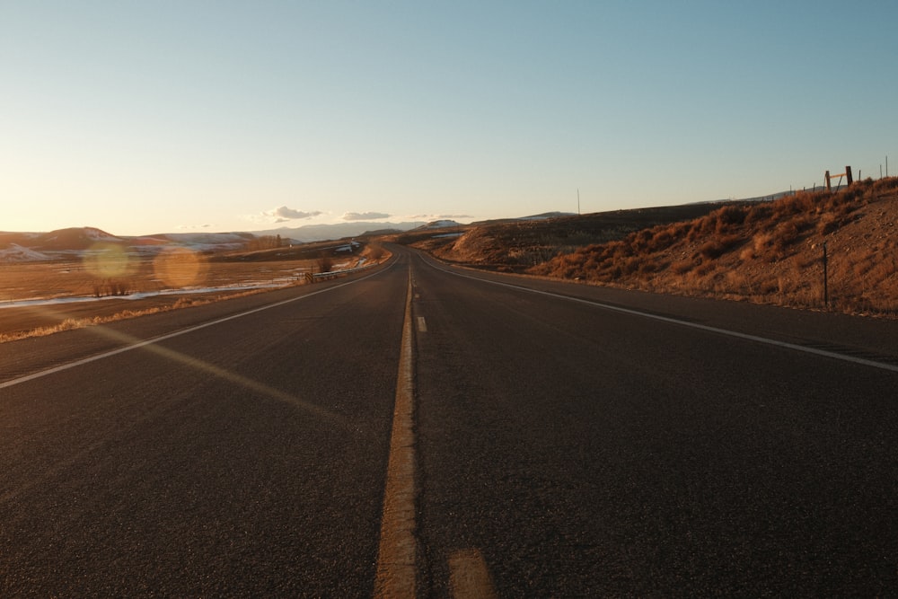 the sun shines brightly on a deserted road