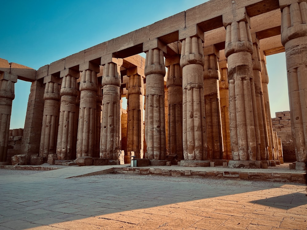 una persona in piedi di fronte a una grande struttura in pietra