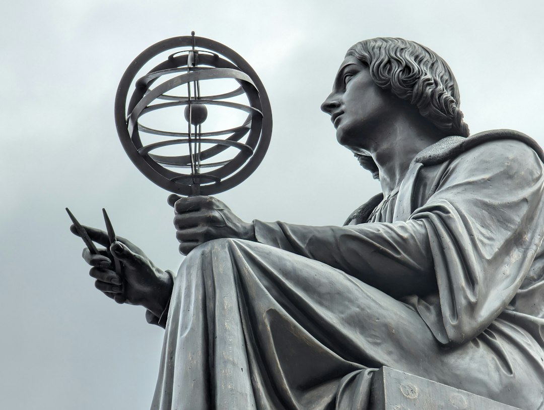 a statue of a man holding a globe, Statue of Nicolaus Copernicus in Warsaw.