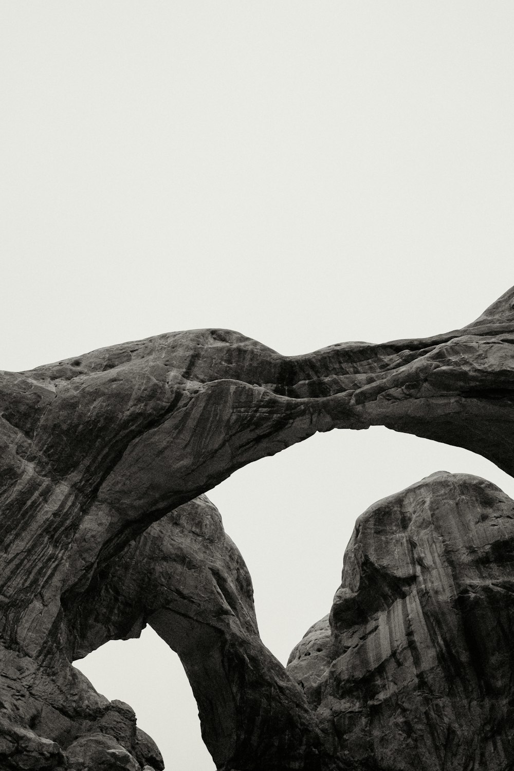 a black and white photo of a rock arch