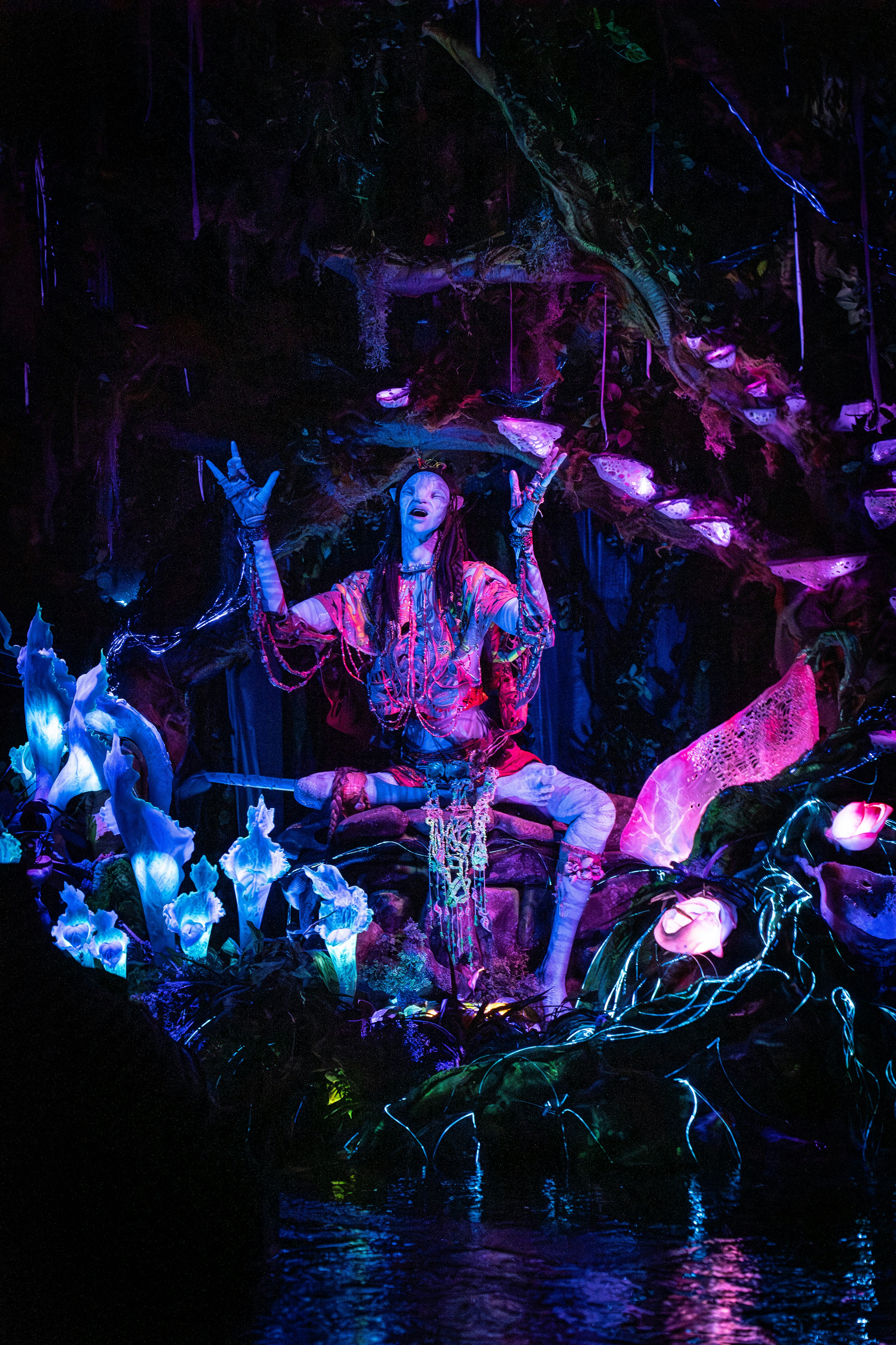 a statue of a man sitting on top of a body of water