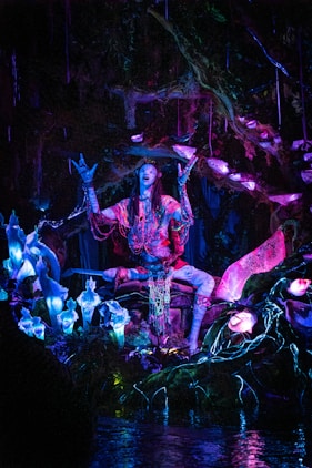 a statue of a man sitting on top of a body of water