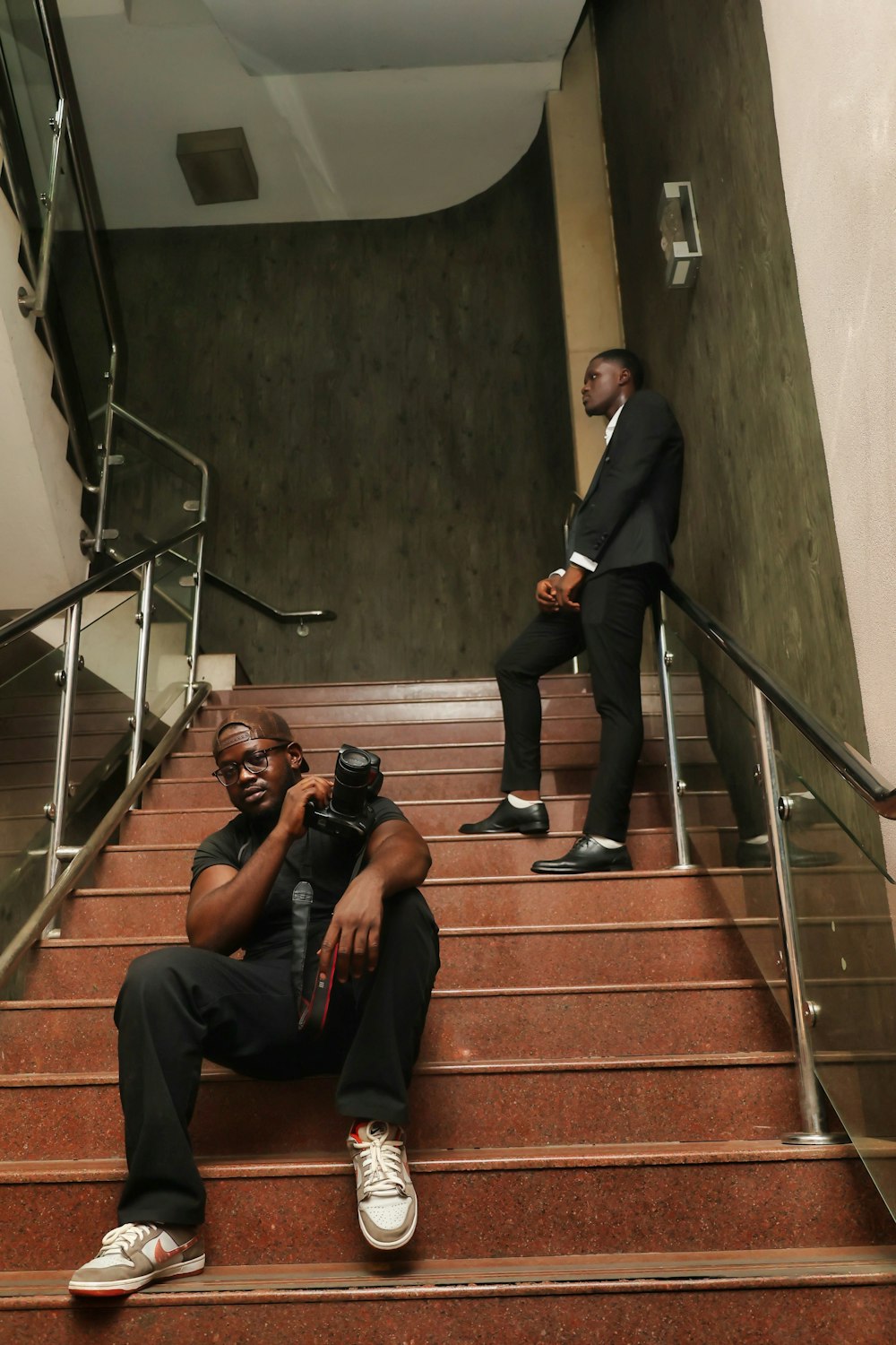 a couple of men sitting on top of a set of stairs