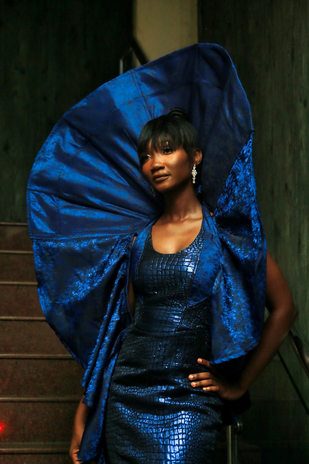 a woman in a blue dress holding a blue umbrella