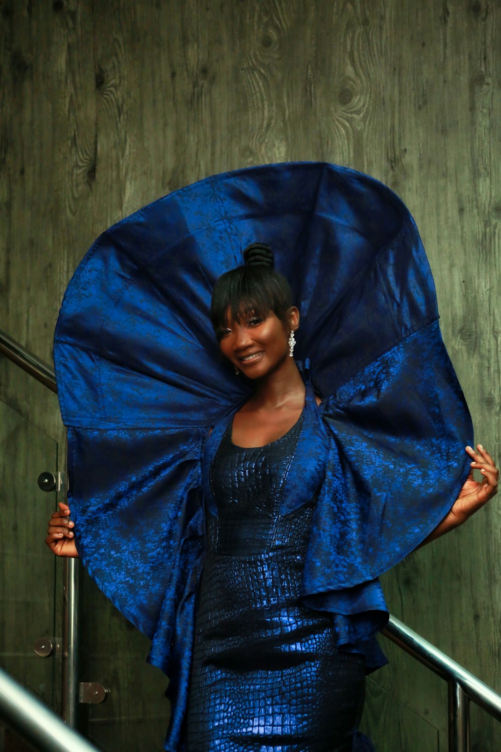a woman in a blue dress holding a blue umbrella