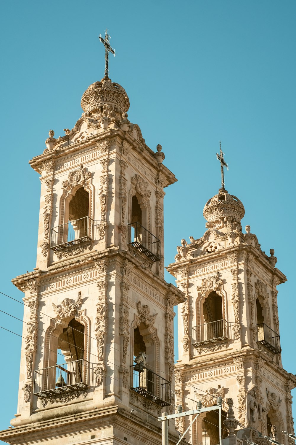 a tall building with two towers and a cross on top