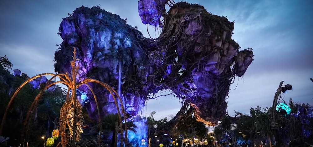 un grand arbre couvert de lumières violettes et bleues