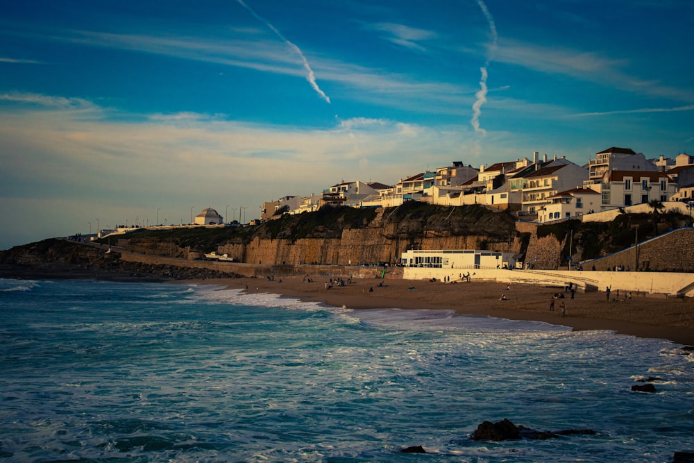 a view of a beach with houses on a cliff