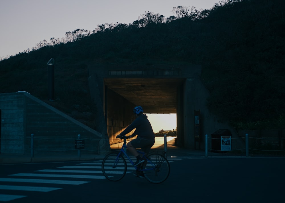 a person riding a bike through a tunnel