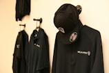 a black jacket hanging on a white wall