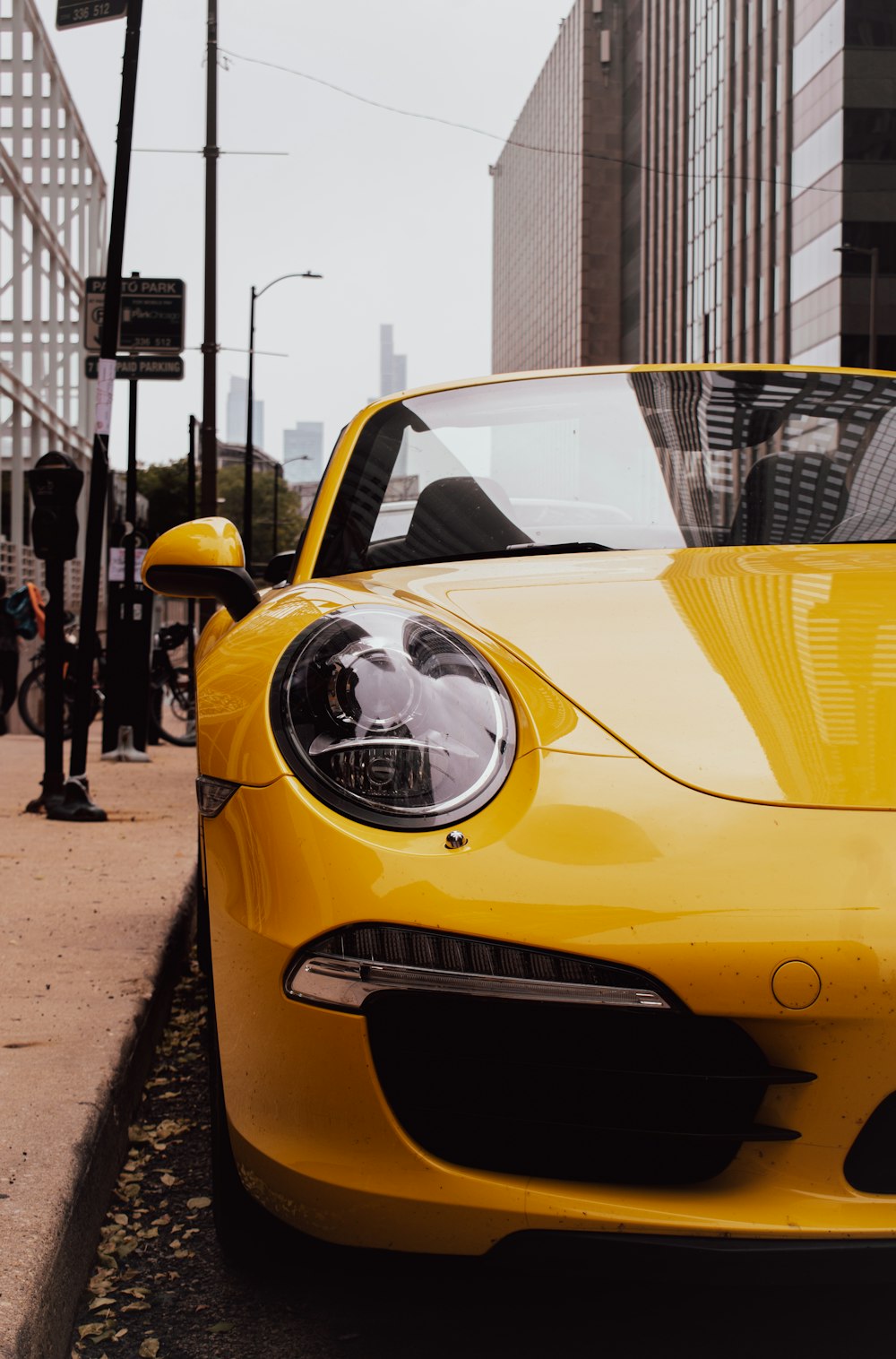 a yellow sports car parked on the side of the road