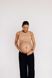 a pregnant woman standing with her hands on her belly