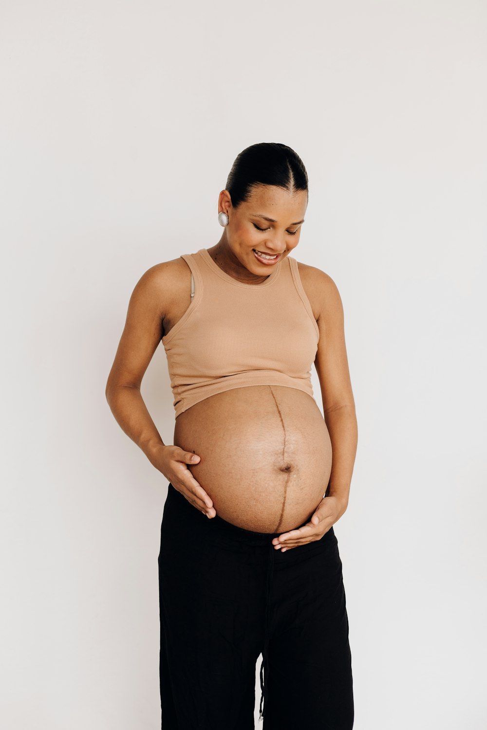 a pregnant woman standing with her hands on her stomach