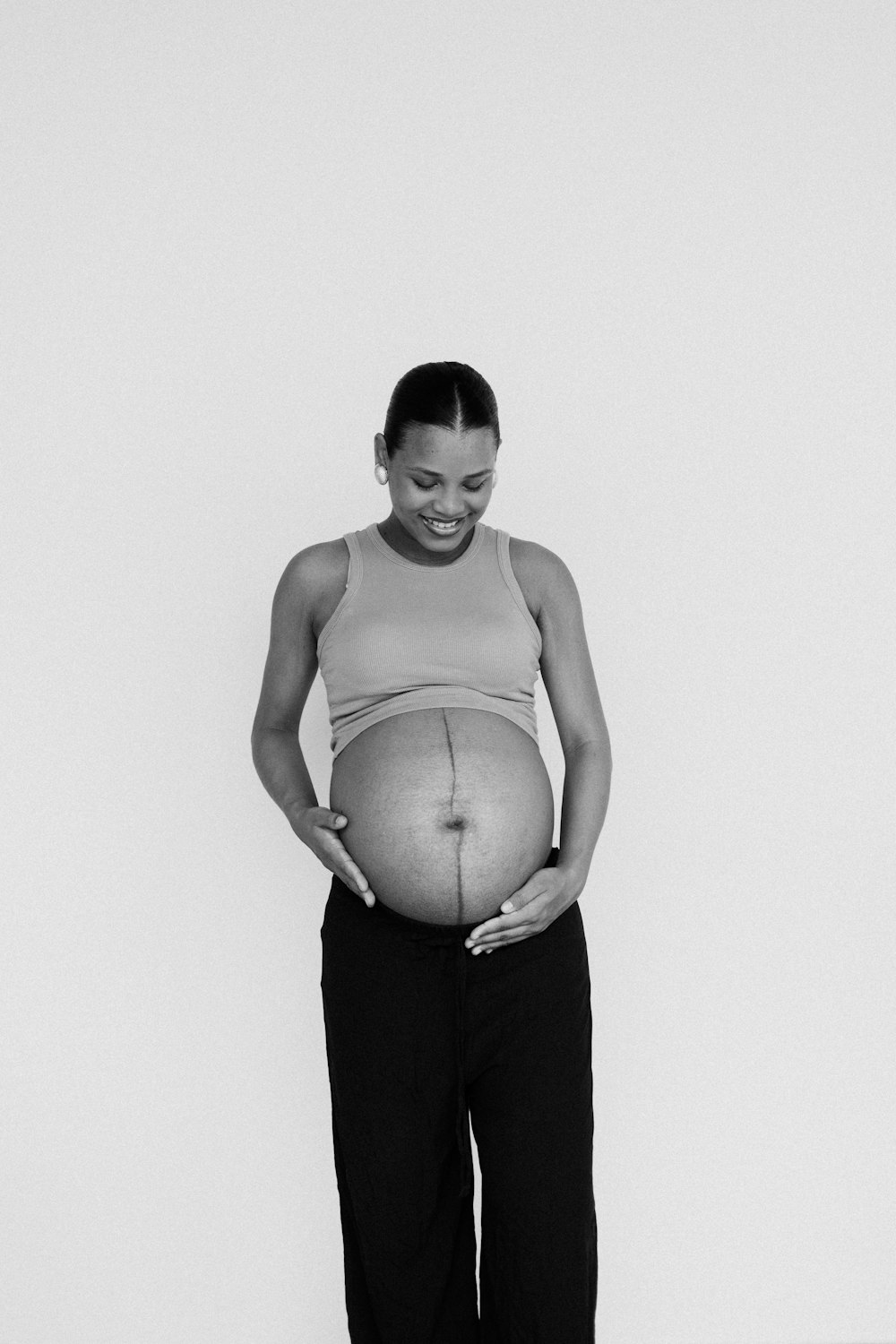 a pregnant woman holding her belly in a black and white photo