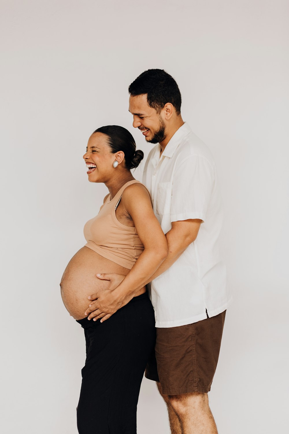 a pregnant man and woman standing next to each other