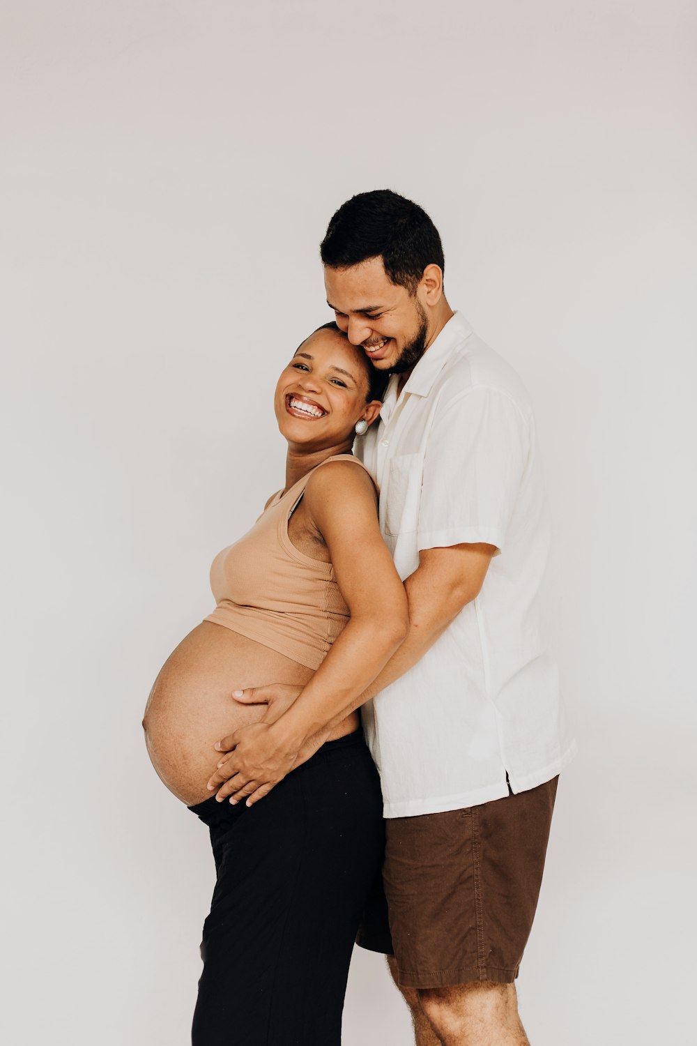 Ein schwangerer Mann und eine schwangere Frau posieren für ein Foto