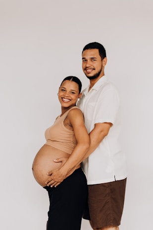 a pregnant man and woman pose for a picture