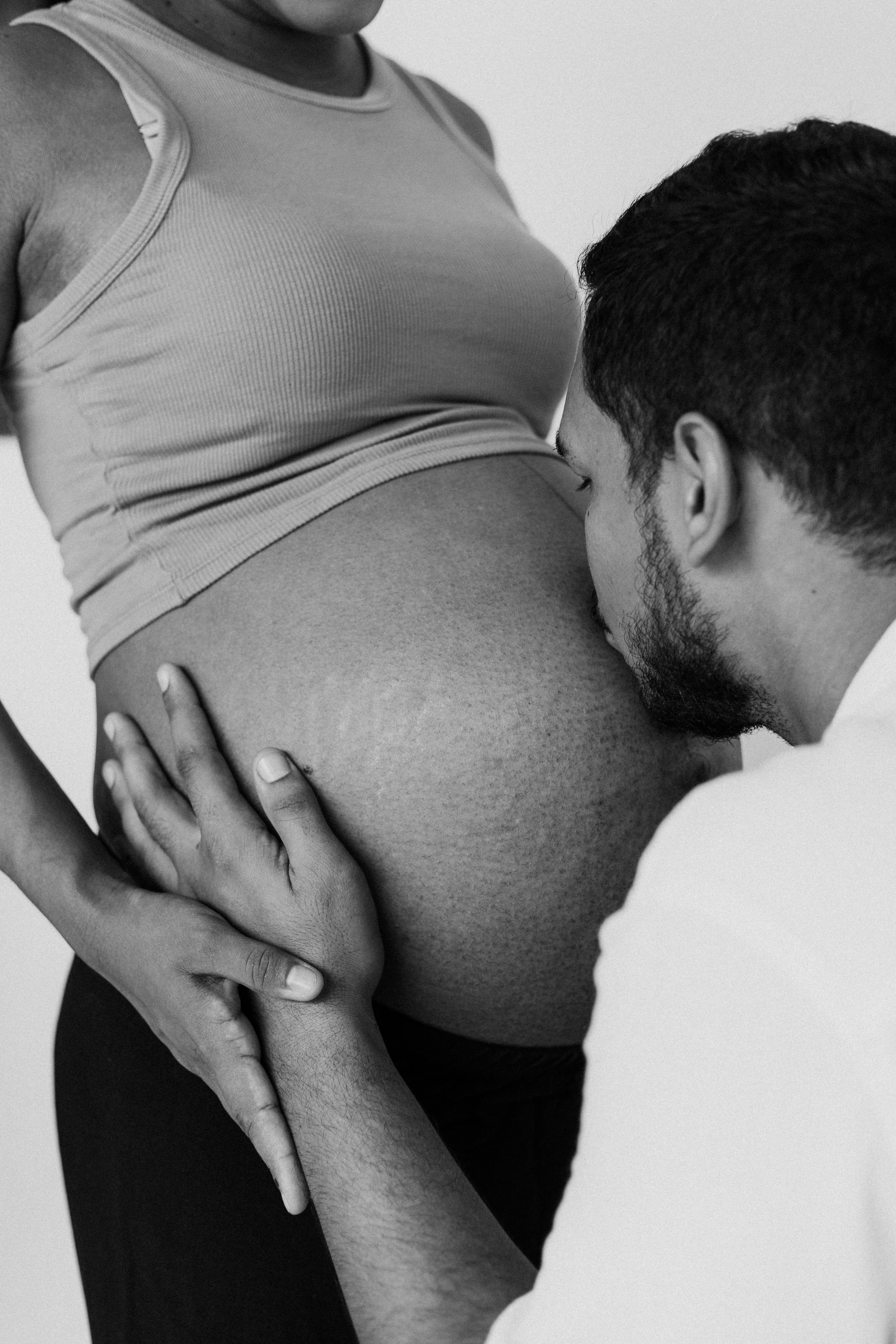 a black and white photo of a pregnant man