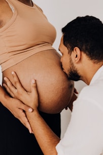 a pregnant man is touching his pregnant belly