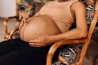 a pregnant woman sitting in a wicker chair
