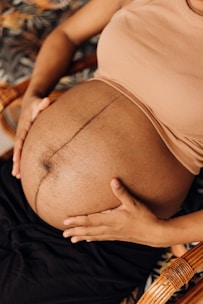 a pregnant woman sitting in a chair holding her belly