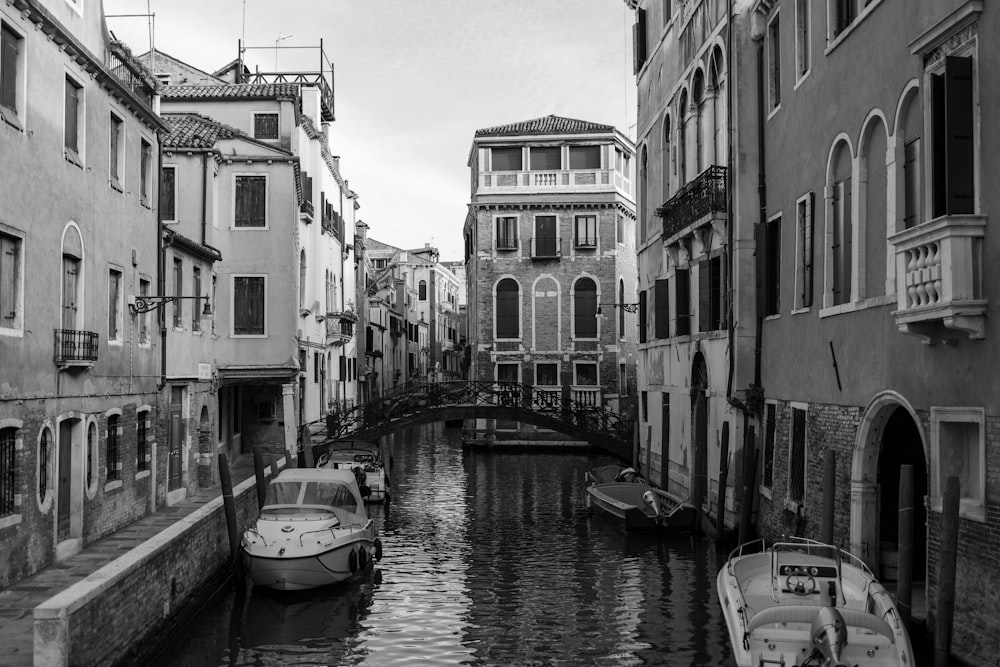 a black and white photo of a canal in venice