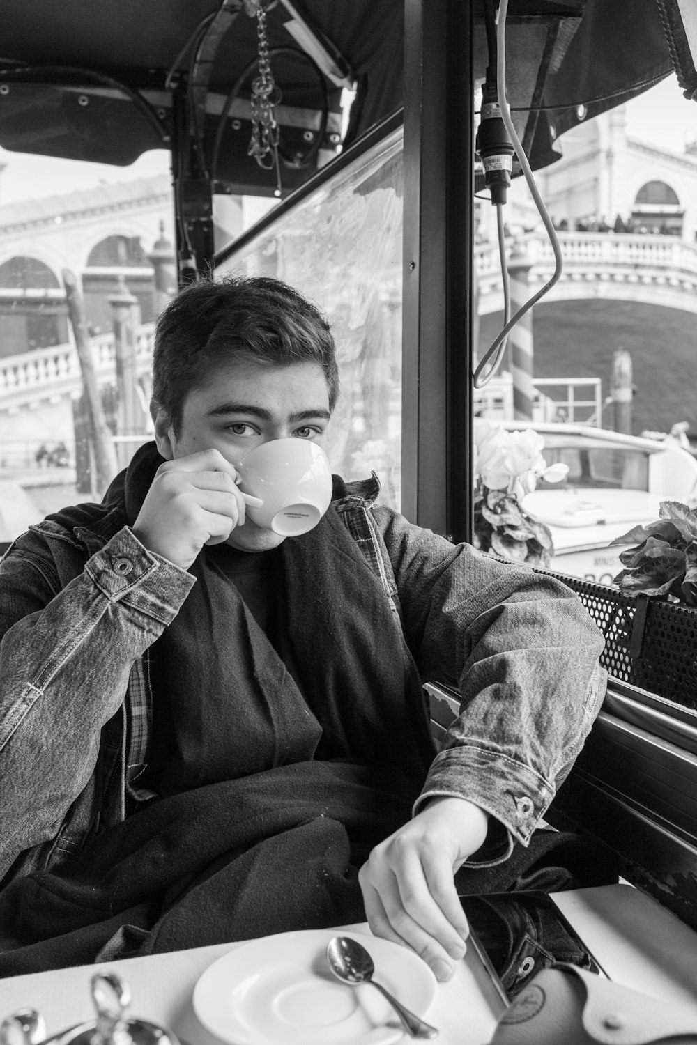 a man sitting on a bus drinking a cup of coffee