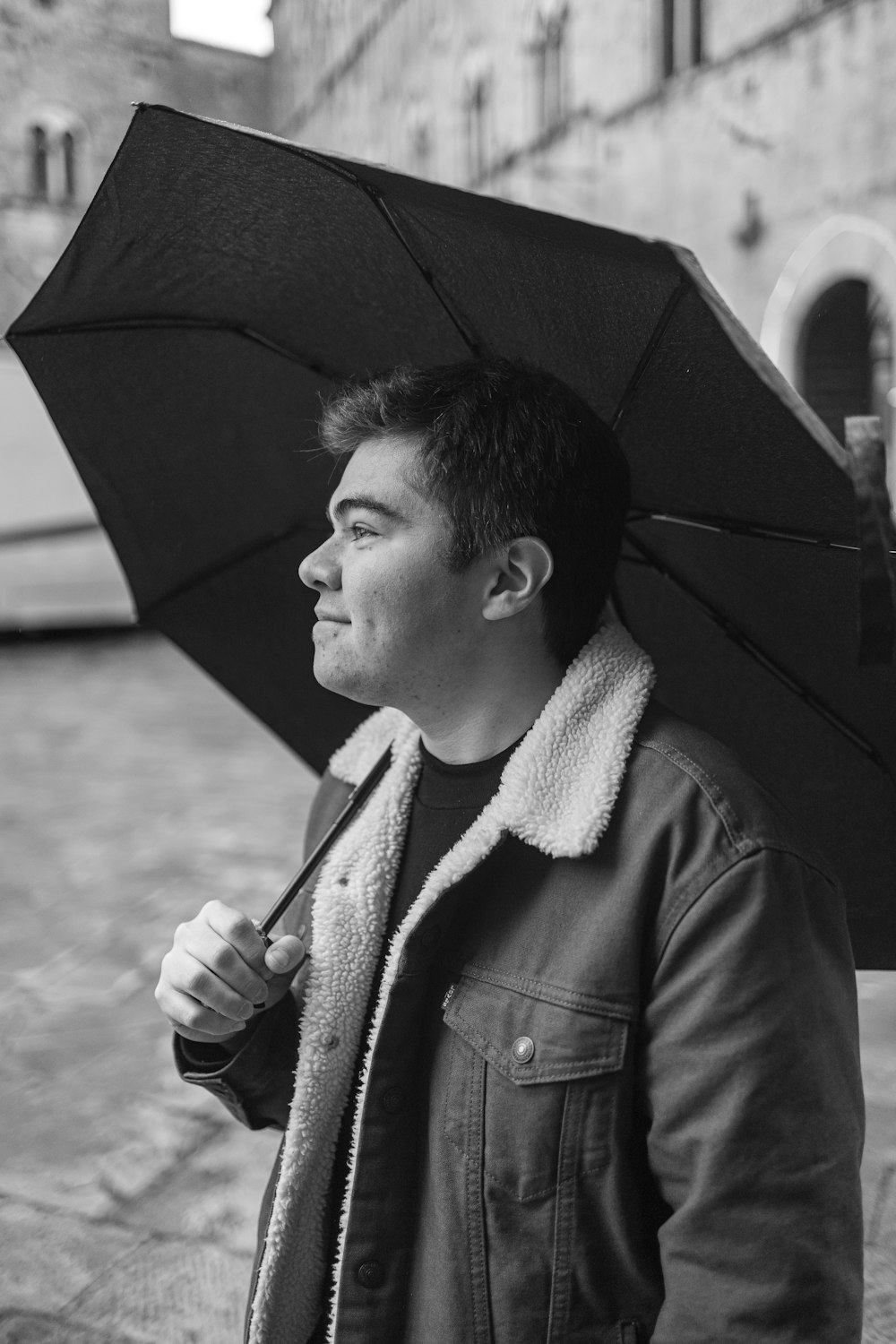 a black and white photo of a man holding an umbrella
