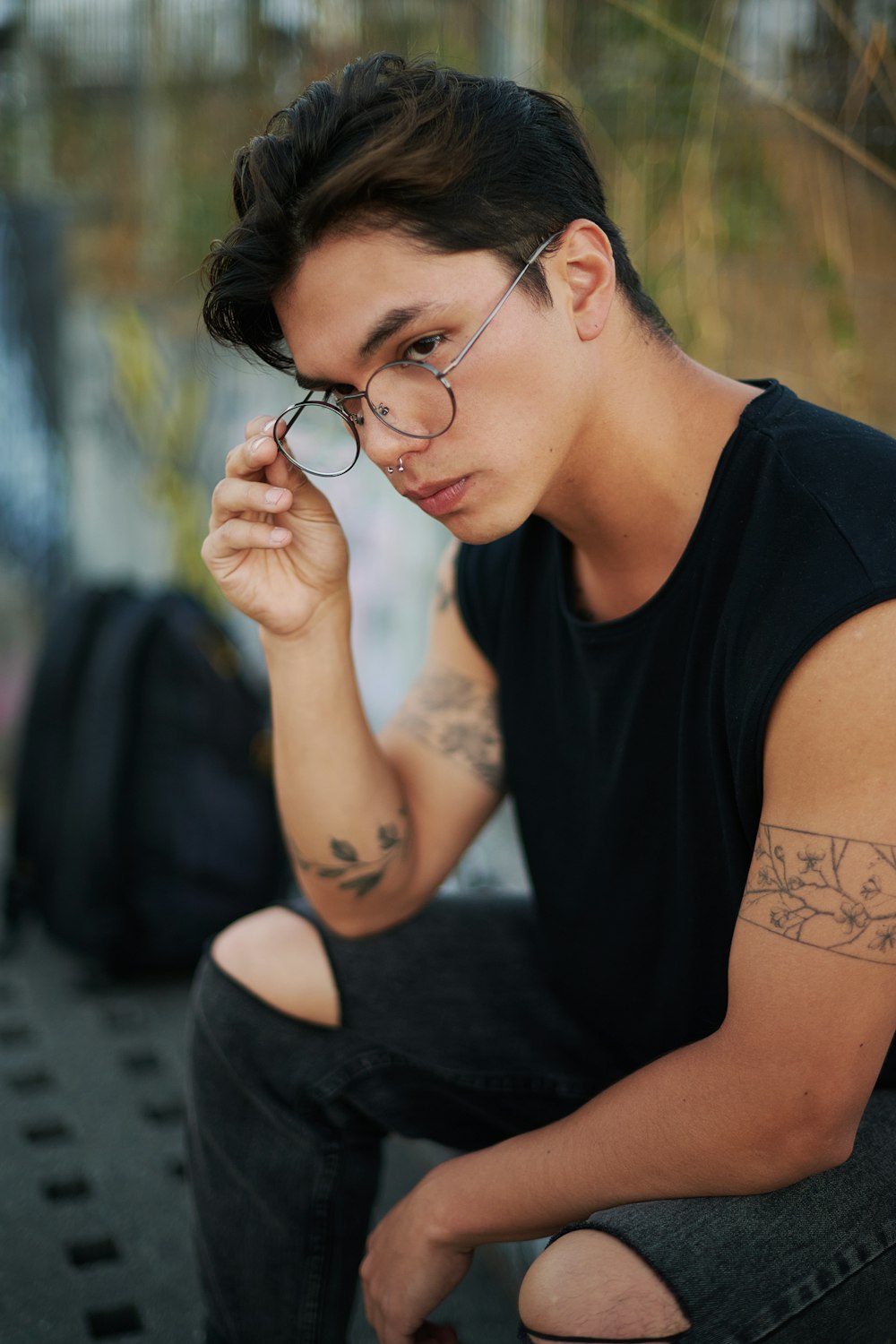 a man with a tattoo on his arm and glasses
