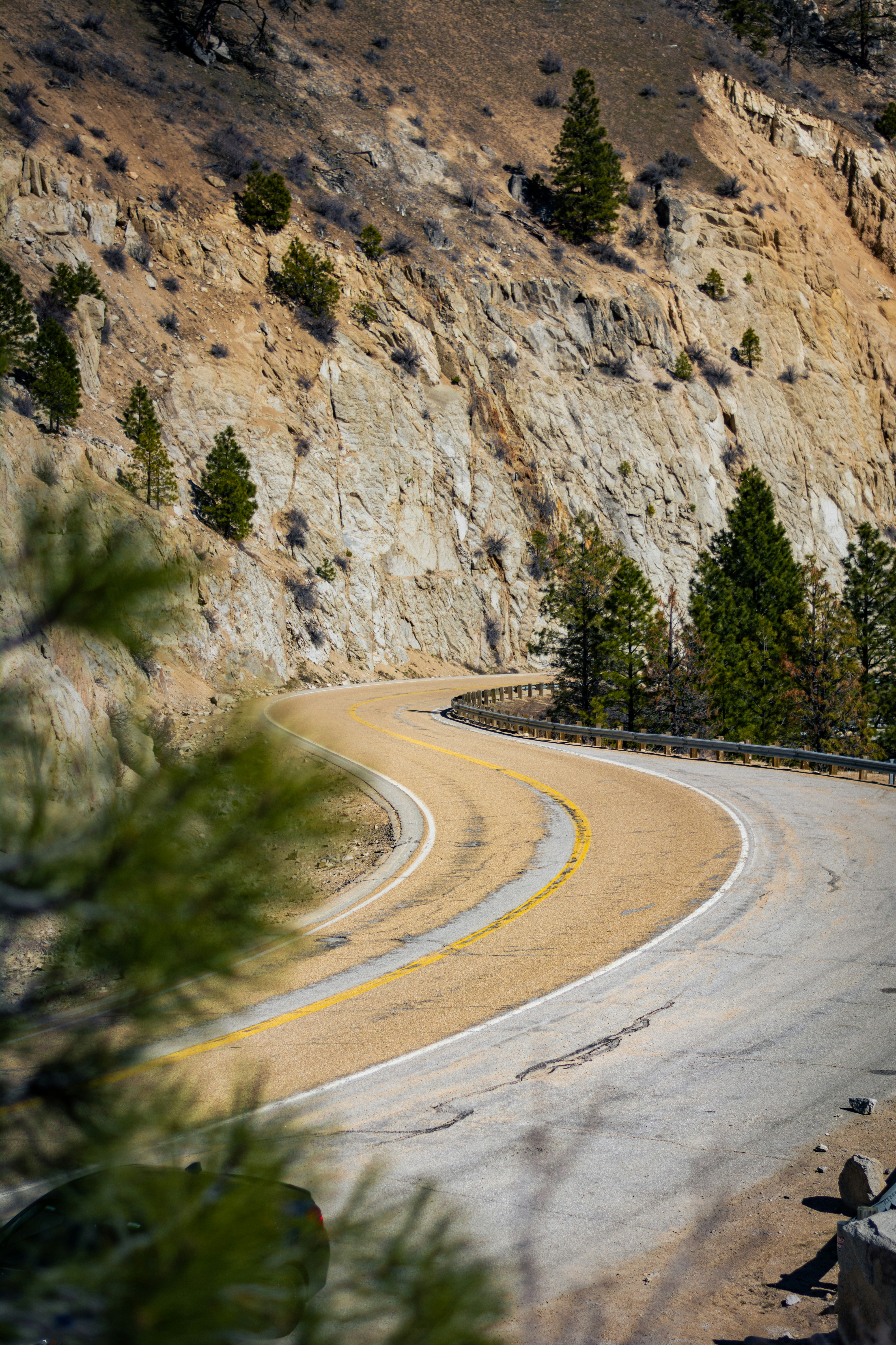 a curve in the road with a mountain in the background