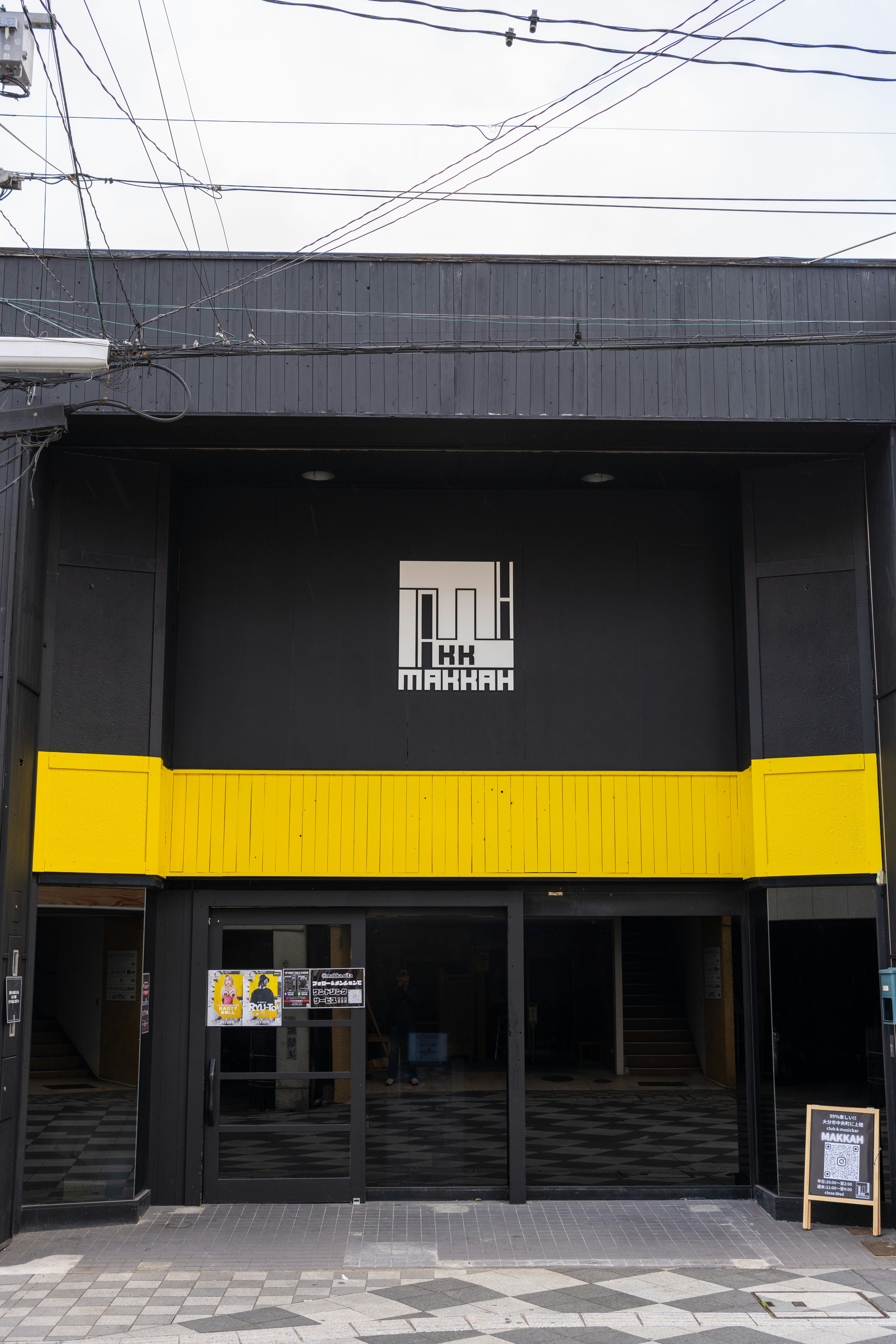 a black and yellow building with a sign in front of it