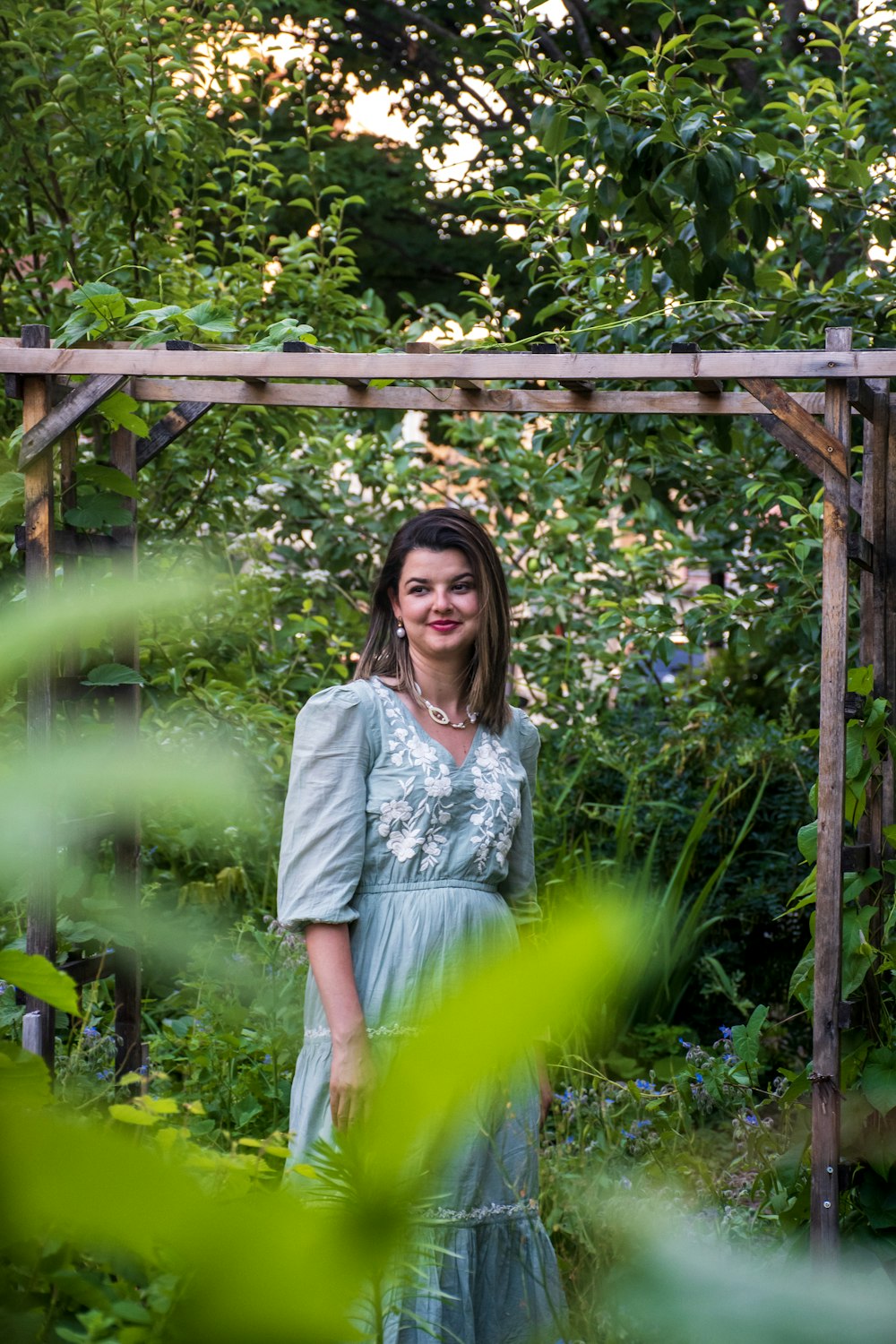 eine Frau in einem Kleid steht in einem Garten